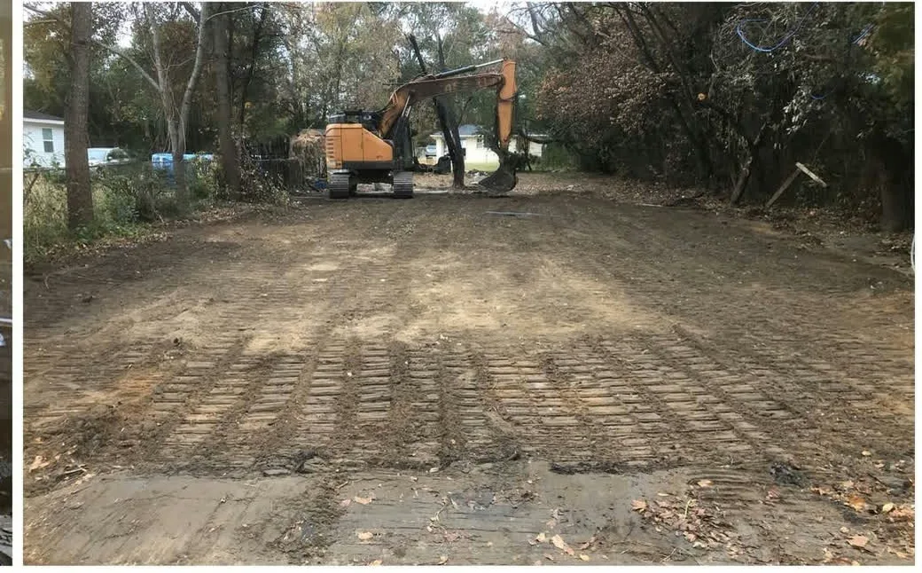 Excavator finishing grade on a cleared residential lot